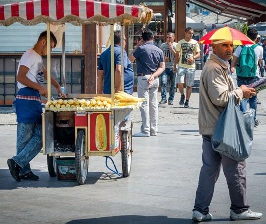 Sokak Satıcılarının Şehir Kültüründeki Yeri ve Önemi Şehir yaşamının vazgeçilmez bir parçası olan sokak satıcıları, hem ekonomik hem de kültürel açıdan önemli bir role sahiptir. Geniş bir ürün yelpazesi sunmaları, günlük hayatta pratik çözümler sağlamaları ve şehrin dinamizmini yansıtmaları, onları kent kimliğinin ayrılmaz bir unsuru haline getirir. Özellikle büyük şehirlerde sabahın erken saatlerinden gece geç saatlere kadar çalışan bu satıcılar, yerel ekonomiye de ciddi katkı sağlar. Konulu bir haber görseli.